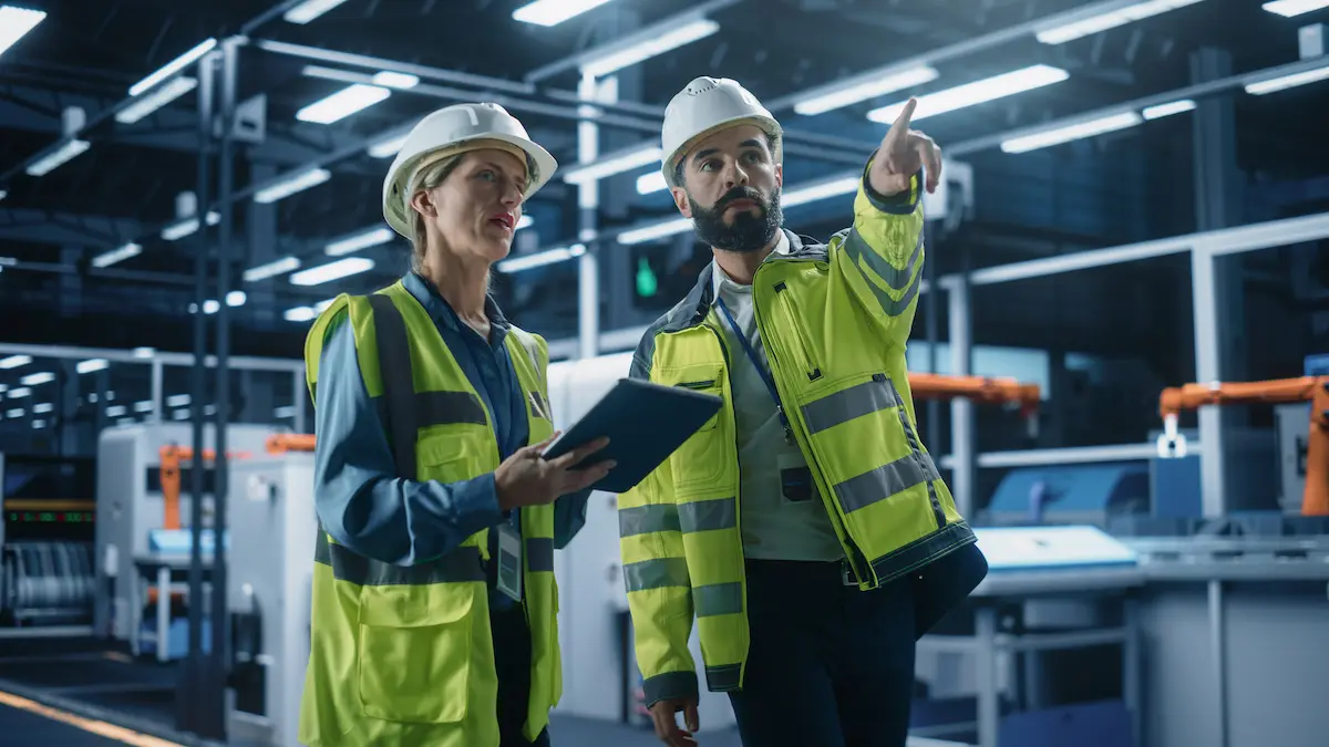 Montagehelfer bei Planung und Produktionsabstimmung in einem Industriebetrieb.